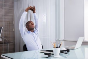 Stretch at your desk to avoid back pain.